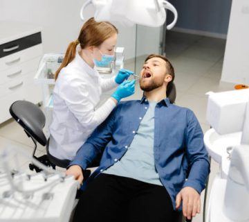 a handsome man is sitting in a chair at a womans appointment at the dentists office 5