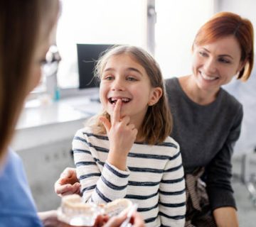 a small girl mother and dentist in surgery dental checkup