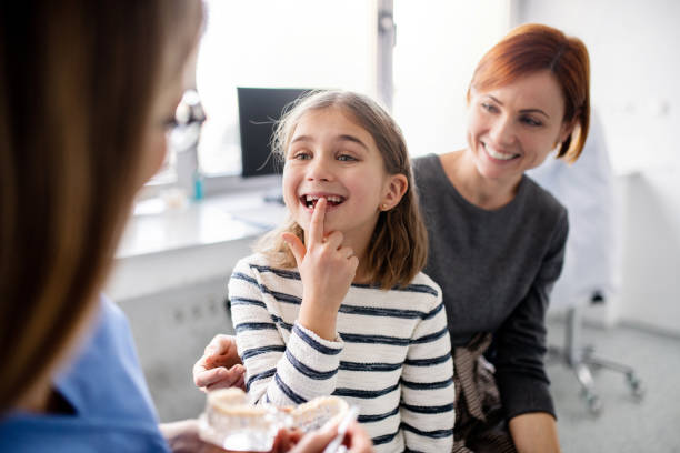 a small girl mother and dentist in surgery dental checkup