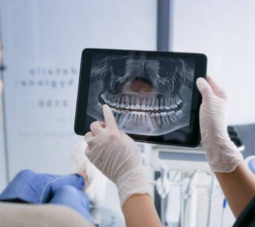 hands tablet and teeth xray dentist and patient with dental surgery and health people and 1