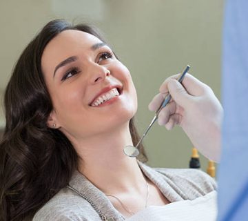 a woman at the dentist getting her teeth checked out