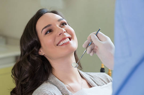 a woman at the dentist getting her teeth checked out