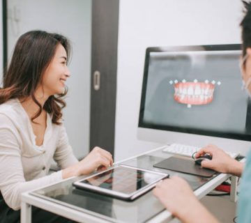 asian chinese male dentist explaining tooth x rays to a patient 1