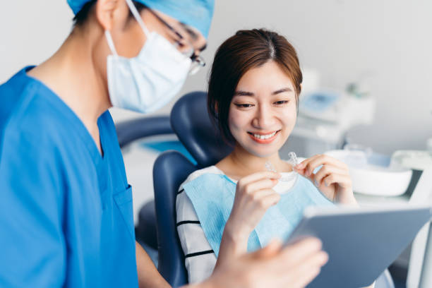 asian dentist explaining tooth x rays to a patient with digital tablet asian young attractive 1