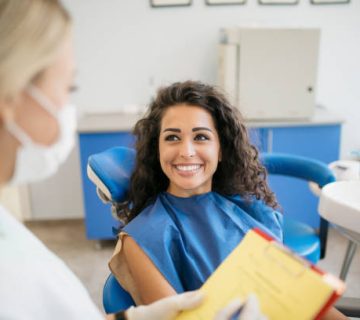 attractive young caucasian woman talking to her dentist