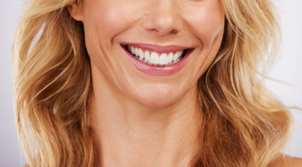 closeup smile and woman mouth in studio for dental hygiene or teeth whitening on grey