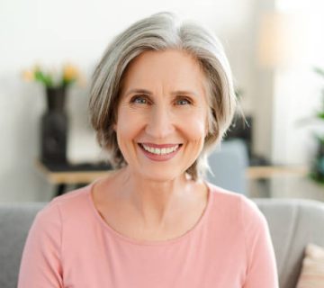 confident smiling senior woman sitting on sofa looking at camera natural beauty healthy 1