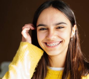 cute and happy teen girl with braces smiling to camera