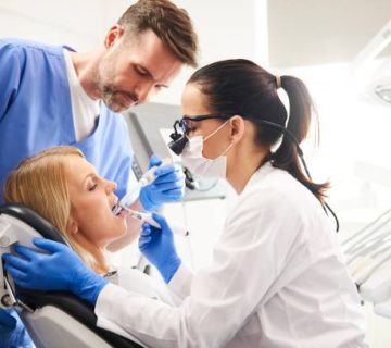dentist and her assistant doing their work in dentists clinic