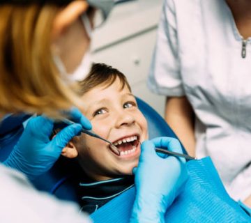 dentists with a patient during a dental intervention to boy 1