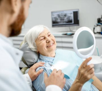 elderly woman enjoying her smile in the dental office