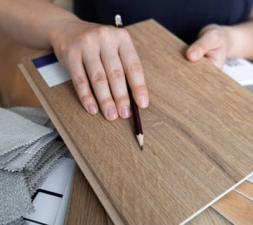female interior designer showing wood flooring samples assisting clients in choosing shades