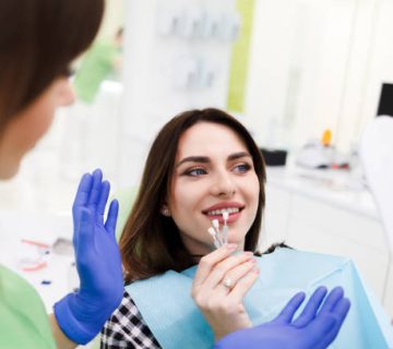 girl chooses color of veneers at the dentist office 1