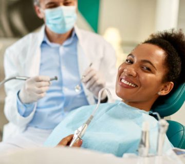 happy black woman at dentists office looking at camera