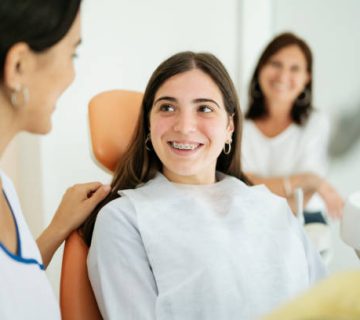 happy teenage patient smiling at female dentist 1