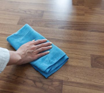 housewife hand cleaning laminated wooden floor