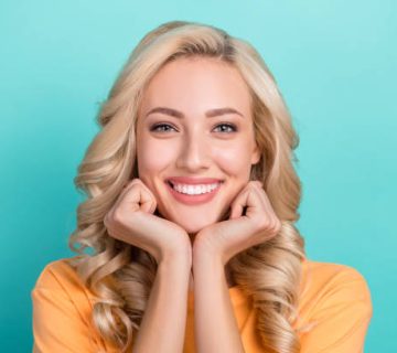 photo of gorgeous adorable woman with curly hairdo dressed stylish t shirt arms on cheekbones