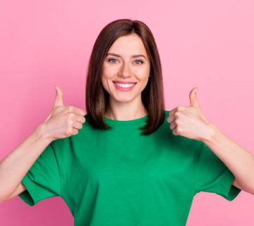 photo of young happy cute pretty woman hold thumbs up recommend new stomatology whitening