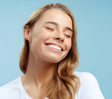 portrait of beautiful smiling woman eyes closed with perfect makeup and silky wavy hair