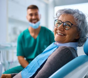 satisfied senior woman at dentists office looking at camera 3