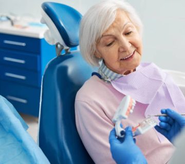 senior citizen listening to orthodontist explanation of human teeth 1