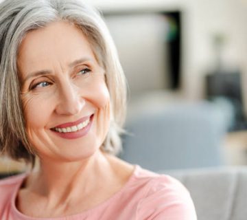 smiling confident senior woman sitting on comfortable sofa at home happy female looking away 1