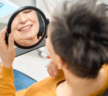 woman client checking her smile and state of teeth after hygienic cleaning 1