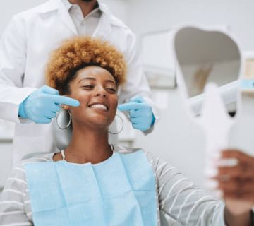 woman in dentist office holding mirror 2